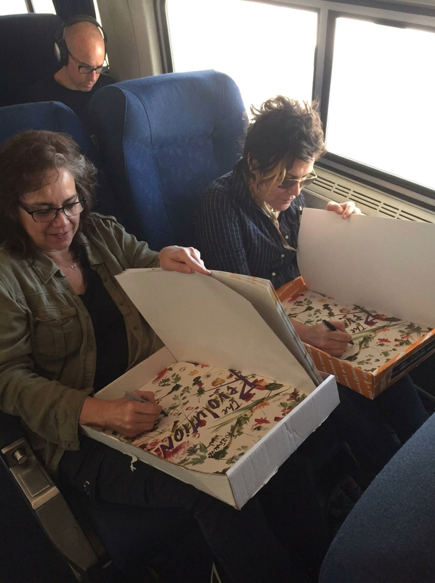 The Revolution band members signing autographs on floral posters